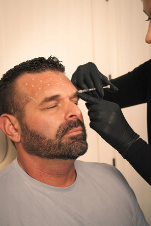 Male client receiving Botox neurotoxin injection treatment at Santa Ana medical spa
